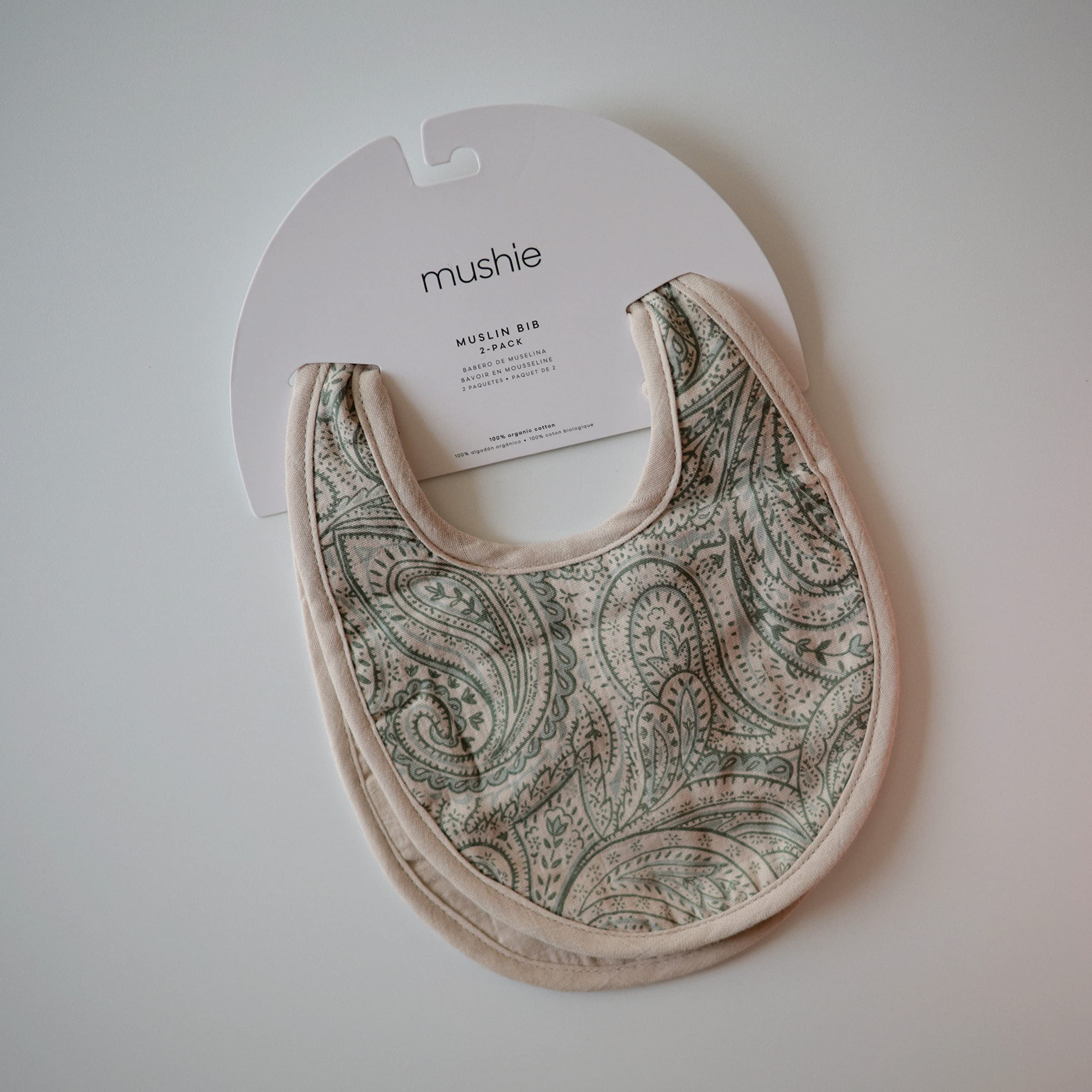 mushie Muslin Baby Bib | Soft Cotton for Infant Drips, Drools & Feedings | Adjustable Fit | 2 Pack (Green Paisley/Fog)